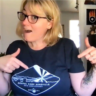 AmyJune Hineline pointing at her DrupalCamp Ashville t-shirt