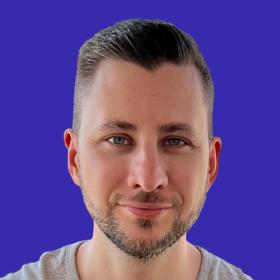 Bálint Kléri smiles at the camera against a purple backdrop