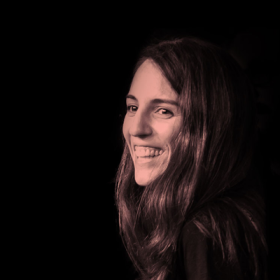 Cristina Chumillas smiling against a dark background